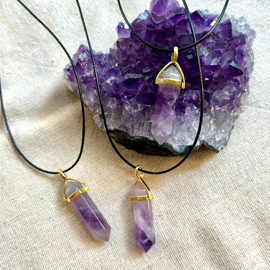 Amethyst point pendants on amethyst cluster